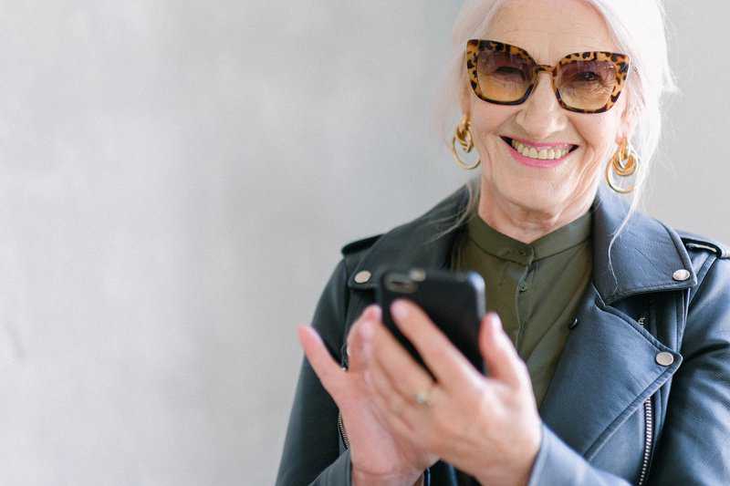 woman smiling with phone | Houston family dentist 77077