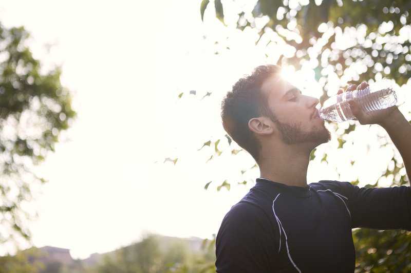man drinking water outside | family dentist for veneers, crowns, clear aligners houston 77077
