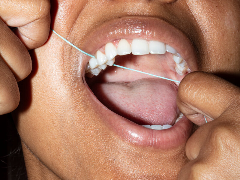 Woman flossing teeth.